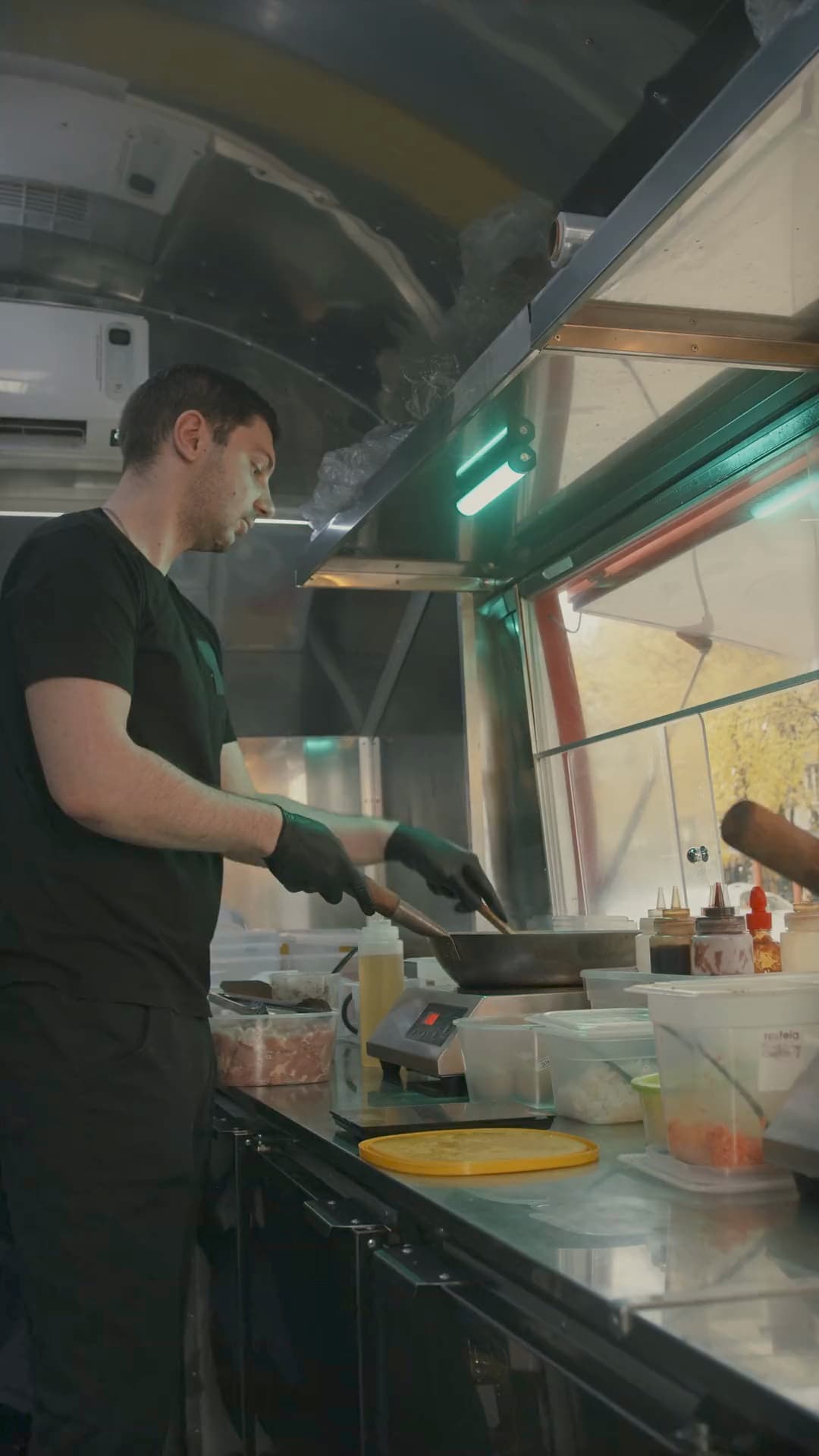 A cook works the pass inside a food truck at lunchtime